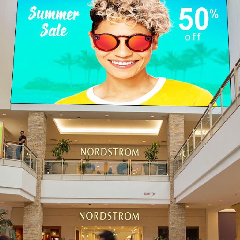 A large sign in a mall with video content on a large LED display wall