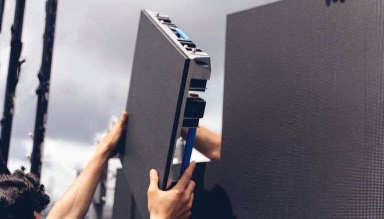 Hands putting a LED cabinet into place on an LED display wall